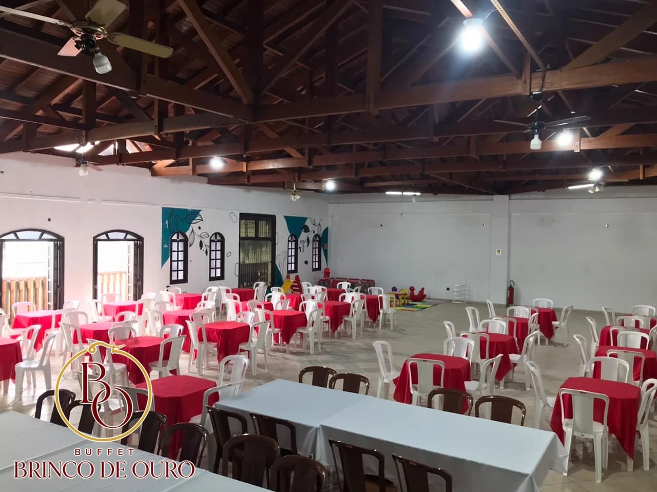 Vista panorâmica do salão com mesas para eventos e estrutura de madeira aparente