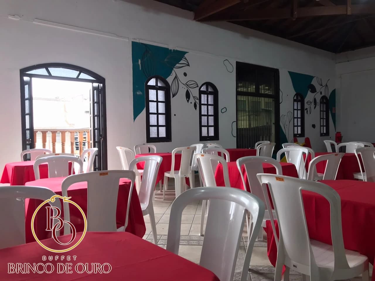 Mesas próximas às janelas e à parede decorada do salão